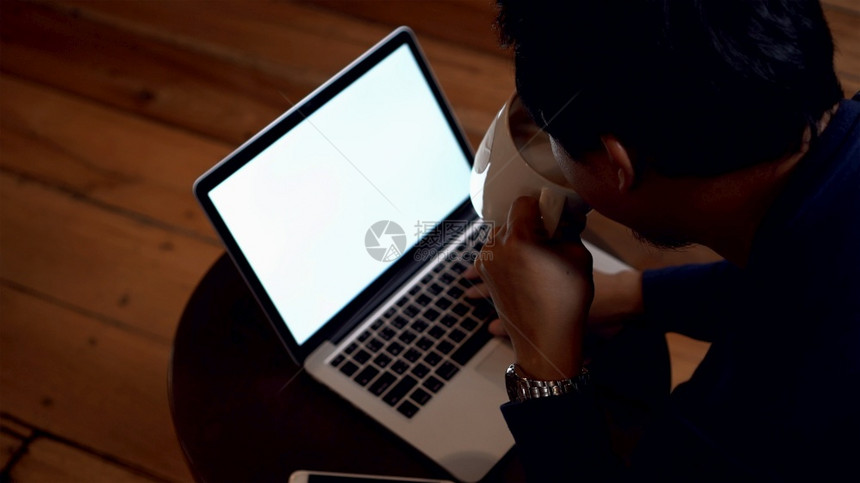 亚洲商人衣着便喝咖啡在厅用白屏幕笔记本电脑工作环境低轻生活方式和休闲概念等低光环境在职的信息潮人图片