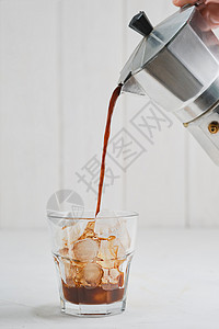 小灰人咖啡倒在玻璃中用咖啡壶里的冰来加准备灰水泥桌上的冰咖啡关闭有选择焦点用咖啡和奶油做新鲜饮料的想法奶油具体凉爽背景