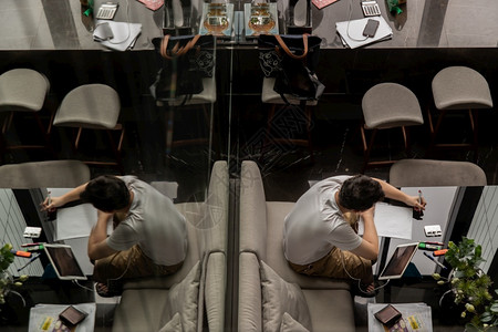 在职的泰国曼谷204年7月日20年月日一名年轻人在共同工作空间的黑桌上工作或在线学习的顶层视野数字游牧民在共同工作空间现代信息技背景