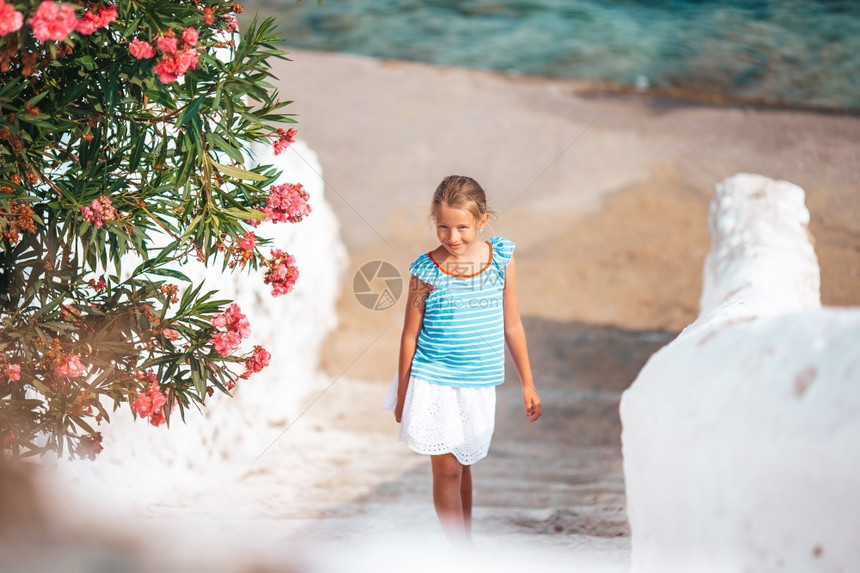 仙人掌圆顶米科诺斯度假户外的女孩在典型希腊传统村落老街上可爱的小女孩老图片
