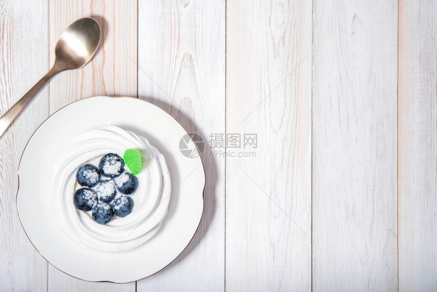 喜庆的健康素食甜点顶端视图在白木桌上配有咖啡匙梅林瓜甜蛋糕和蓝莓免费复制空间设计时您要用在白木桌上配着咖啡勺的健康素食甜点Ann图片