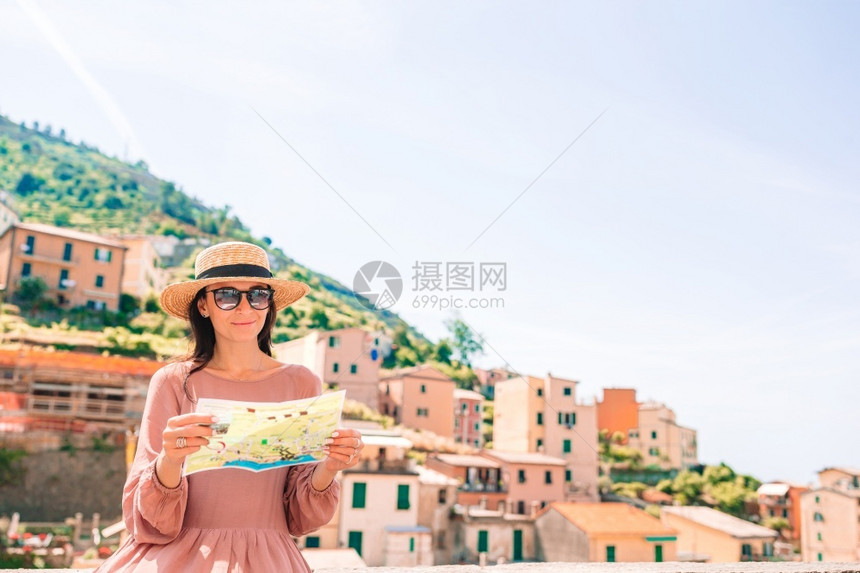 裙子浪漫的镇年轻女子在著名的五渔村里奥马焦雷老享有美景和在利古里亚五渔村奥马焦雷老享有美景的年轻女子图片