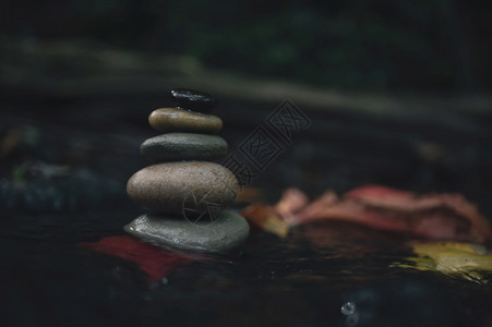 心理平衡碎石堆积成冰块岩浆堆在一起石溪流中形成秋天森林的瀑布Zen就像概念一样雕塑自然温泉背景