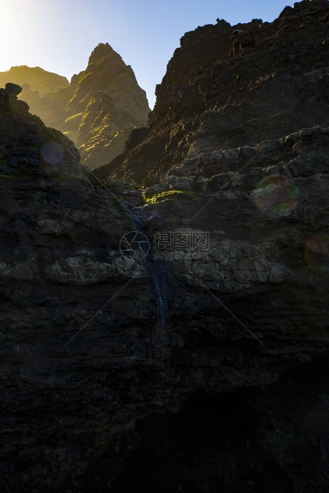 梦旅游边缘夏威夷小瀑布的山上闪耀着阳光图片