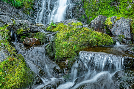 迅速如画夏季日风雨林森中的溪流山崩瀑布在岩和青绿的山区河流之间自然景观森林中红厚的茂密地带有连串的山溪泡沫背景图片