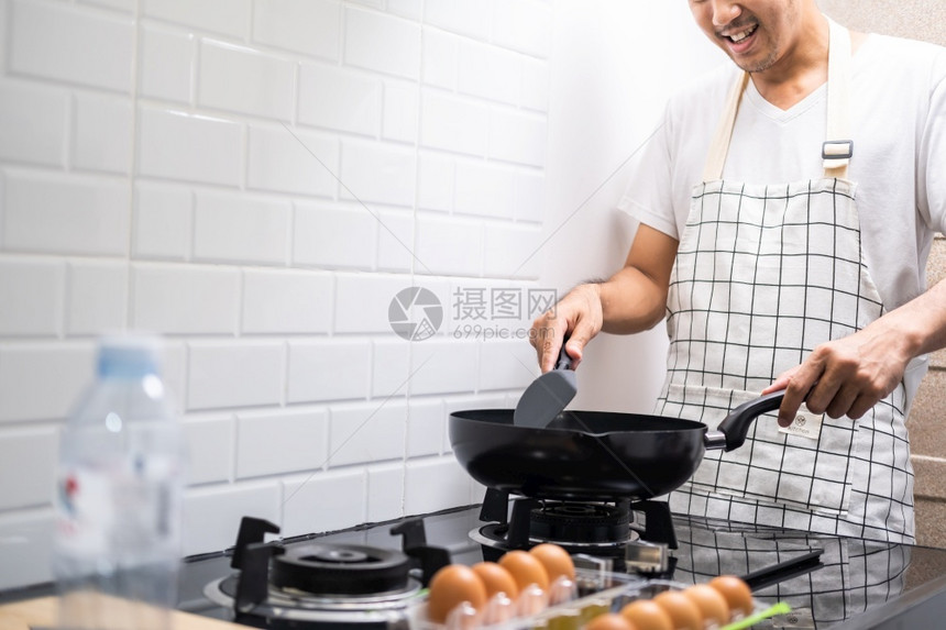 亚洲厨师煎鸡蛋在锅炉煤气的厨房里煮饭在为幸福的家庭做饭前煮锅炒鸡蛋和猪肉中的油在家共进晚餐蛋白质盐早晨图片