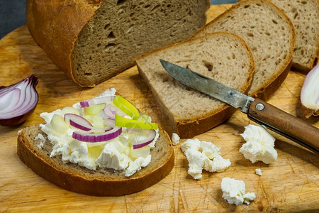 小吃重点蔬菜家用木制切纸板做面包配有卷心起司装饰配有新鲜绿洋葱或春图片