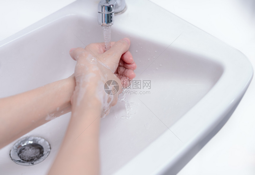 妇女用肥皂泡沫和自来水洗手在浴室水槽上清洁管下净用于个人卫生以防止流感和冠状良好的洗手程序以杀死细菌为了人们干净的图片