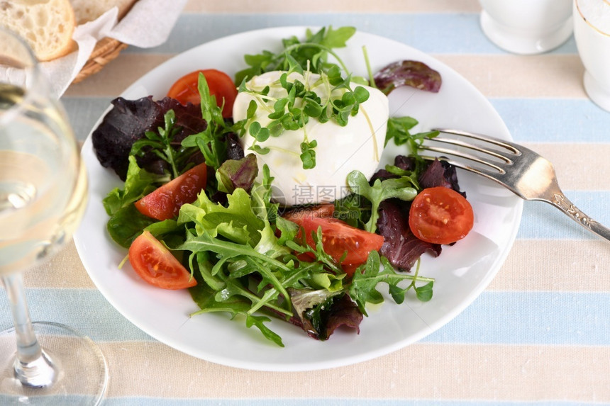 一份健康的沙拉由生菜叶蔬混合绿色部分青菜番茄萝卜芽西红柿萝卜芽和奶油酪橄榄和新鲜面包以及一杯白葡萄酒制成服务卡路里切片图片