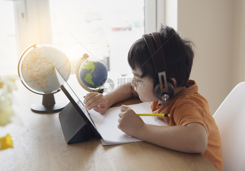 学龄前儿童使用平板电脑做功课的肖像通过在互联网上使用数字平板搜索信息家庭学校教育概念来从事功课的儿童Soft焦点写作读玩图片