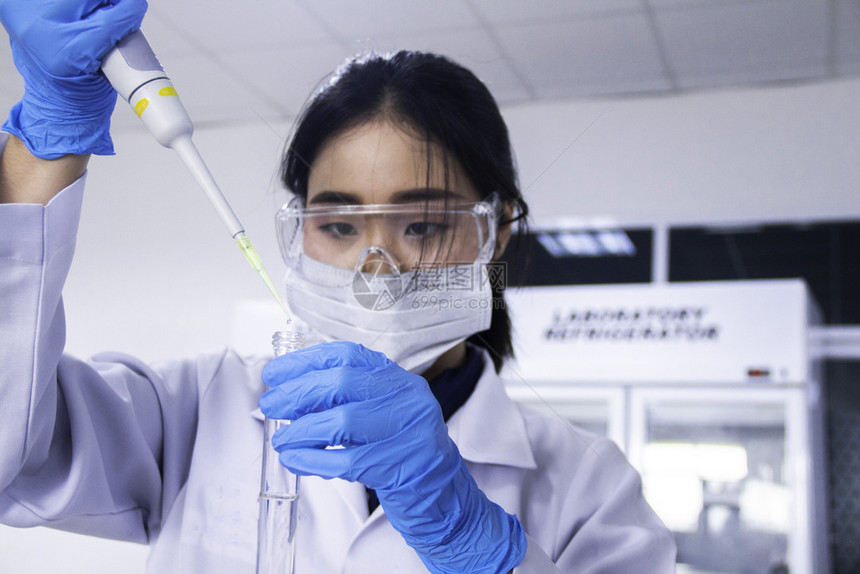 显微镜液体亚洲女化学家选择重点的科学家在一个带有微管子和试概念的实验室中工作科学家与亚洲女化学家选择重点的科学家在实验室工作研究图片