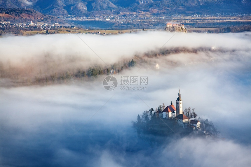 日出一种清晨与小岛上的玛利亚占居地朝圣教堂和山崩中的布莱德城堡和朱力安阿尔卑斯一起雾密的弥漫之夜吸引力图片