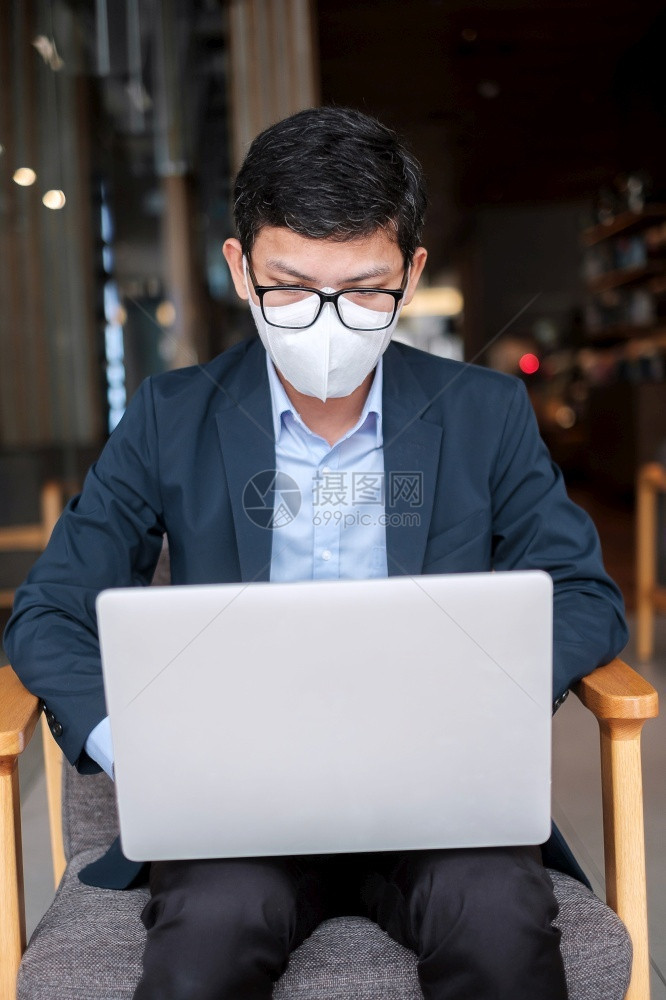 感染身穿外科面罩使用膝上型电脑在办公室或Covid19大流行技术和新正常概念咖啡馆打键盘计算机笔记本的人椅子电脑图片