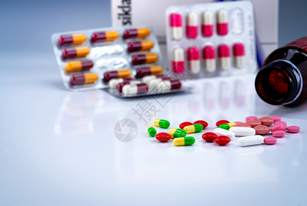 白桌上的平板药片和胶模糊的瓶泡袋和抗生素药箱彩色丸制业剂产品许多胶片和药新冠卫生保健瓶子背景图片