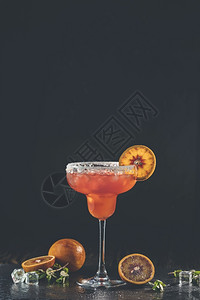 三丫苦红橙玛格丽塔鸡尾酒加龙舌兰三立秒橙汁压碎的冰和玻璃边缘一些盐装饰在片深浅的露天黑石本底柑橘片上经典的反射桌子背景