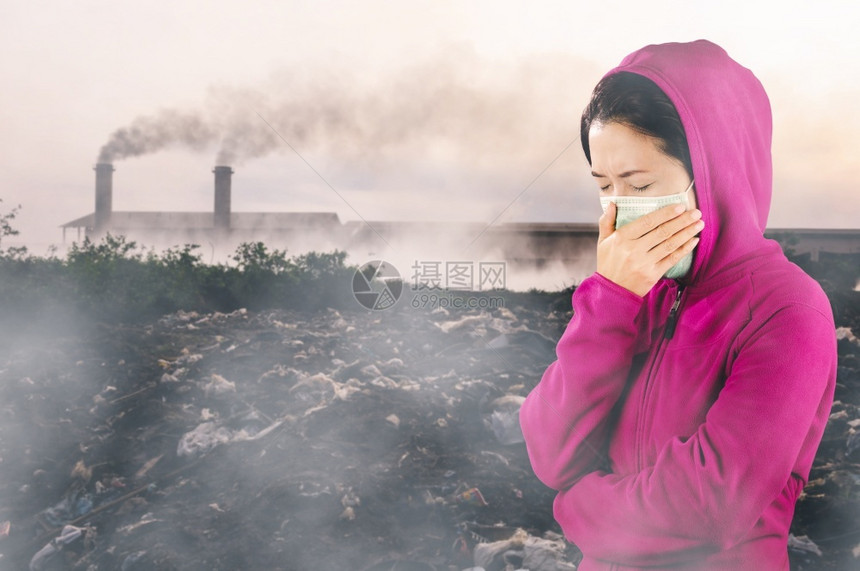 冬天生病的人妇女打流感喷嚏妇女穿粉红色的冬季衣着身戴面罩在感冒和流健康概念下的鼻子上戴面罩反对空气污染背景图片