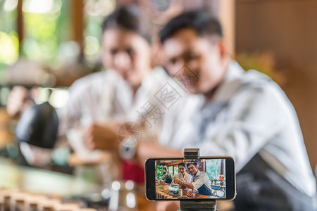 视频及素材浇注向小商业主Vlogger的两个亚洲合作伙伴拍摄并展示如何通过滴方法制造咖啡企业家博客及创概念的智能手机录像影片微小商主Vlo背景
