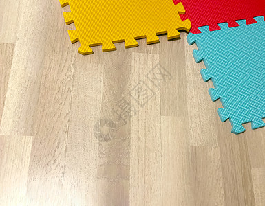 嵌入式教育Linux婴儿软橡胶垫由彩色区块组成在木制地板上相互交叉适合儿童玩耍或瑜伽锻炼内中正方形联锁背景