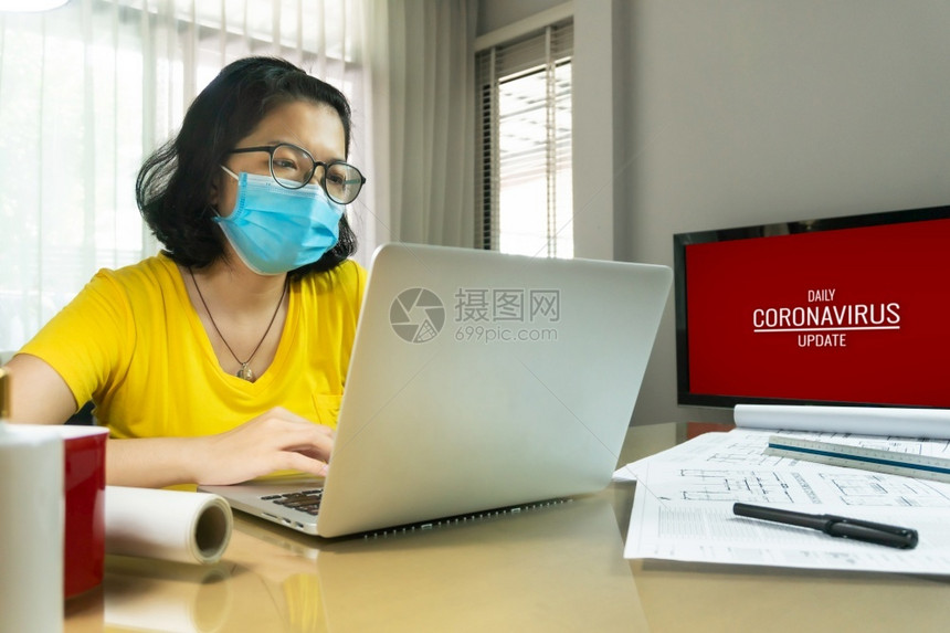 亚洲创意女戴着眼镜与笔记本电脑举行在线视频会议隔绝青年建筑设计师女黄衬衫穿蓝色外科面具工作时在家流行Covid19CoronaC图片