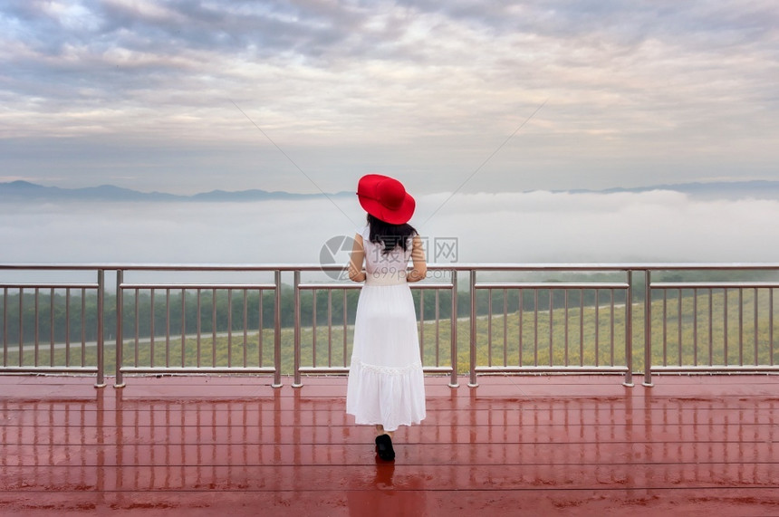 白色的常设墨西哥人她穿着白裙和红色帽子站在泰国兰邦隆省MeeMohCoalMine的TungBuaTong墨西哥向日葵田旁观视点图片