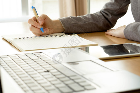 ai可编辑文案女桌子在办公室用笔记本电脑写纸和打字的封闭工作妇女技能背景