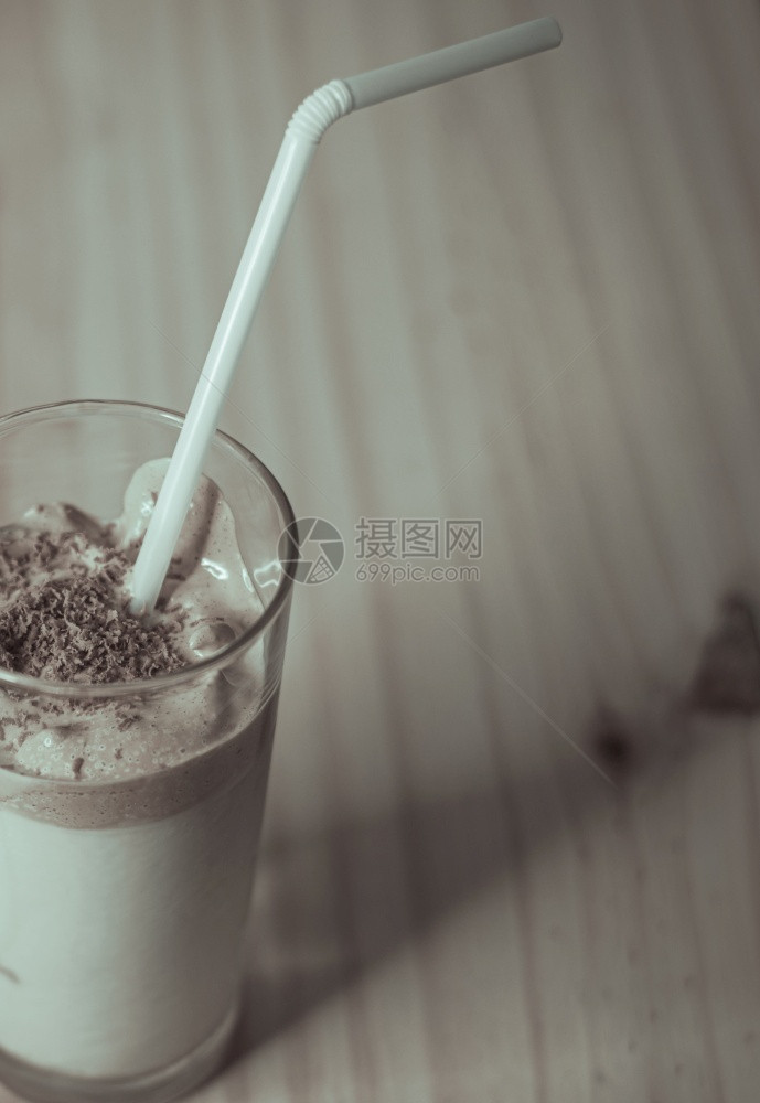 一种逆转在木制的纸质桌面板上自制Dalgona咖啡杯装在木制拖鞋板上用鲜奶冲来即时咖啡使韩国美味饮品Trendy饮料与巧克力屑和图片