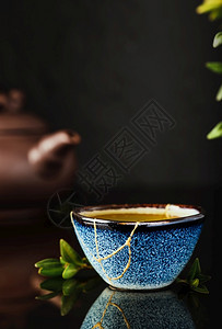 2021年11月30日自然深色背景中的日本绿茶杯有选择地关注杯子回收陶瓷蓝杯事物的第二生命回收或kintsugi青菜美食背景