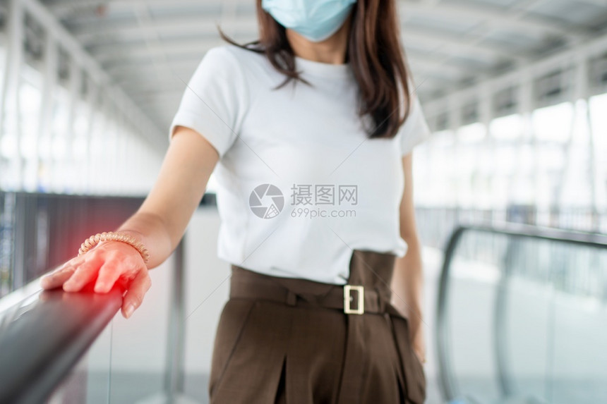 一名年轻妇女身着抗冠状COVID19传染病爆发防护医疗面具但用手扶着可能有和细菌的手力生殖器外形她被蒙在医疗面罩上以进行抗cor图片