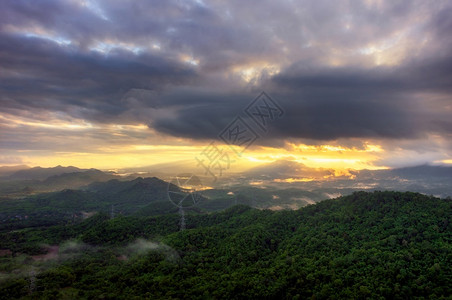 高压电极PangPuayMaeMohLampang泰国兰邦等绿色森林和美丽的清晨光雾和雨暴黑云中空观测发射塔长于绿雾林的高压电极图片