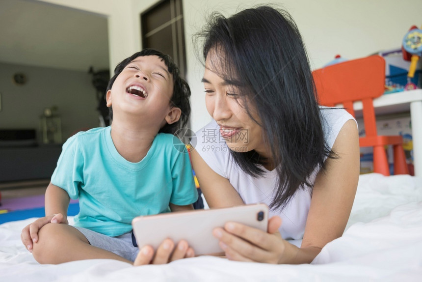 最好的自己新一代家庭父母亲真实联系概念在床上拍摄照片或自视频电话亲属新一代父母身份连接的概念畅快图片