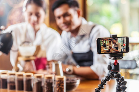视频及素材亚洲人营销向咖啡店和美式小企业所有者及创概念的观众展示一杯咖啡滴水节目在店制作和美式小商业主及启动理念专业的背景