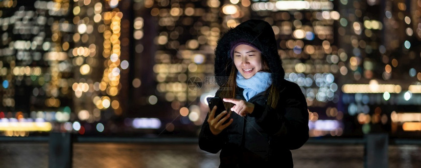 以及冬季西装亚裔女封面使用智能手机微笑动作照片模糊的纽约克市风景BOOKH在东河背景旁边美国市区纽约中心行动亚洲人们图片