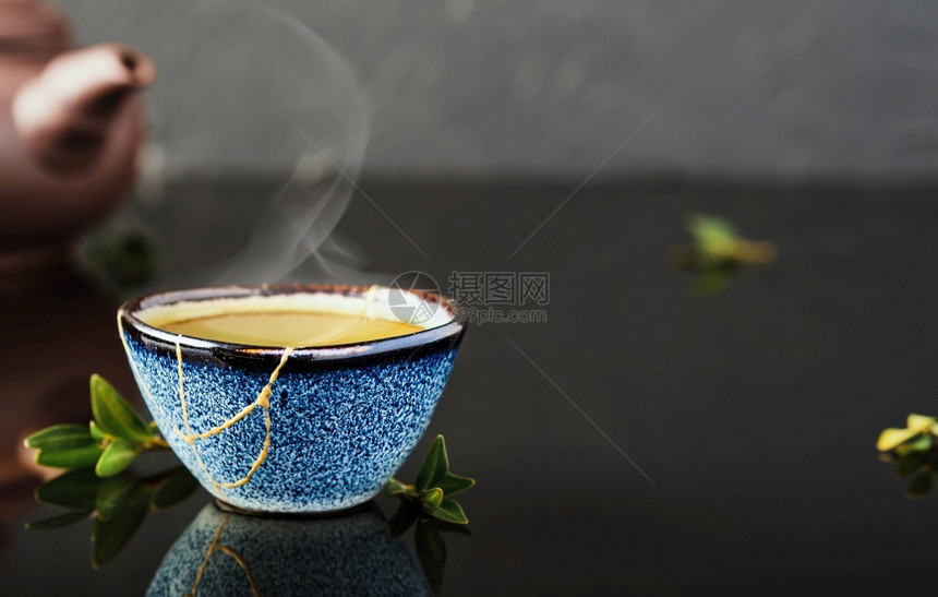 明亮的日本一碗绿色茶叶在杯子旁边选择地关注杯子蒸汽车从碗面上升起重度陶瓷蓝杯第二年的东西循环利用或动脉素基树叶放图片