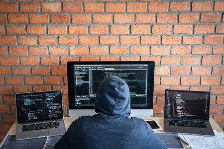 编码联网危险戴头罩的黑客使用多个计算机将坏数据输入在线系统并携带来感染窃取信息IfterHebcackhacker或网络攻击概念图片