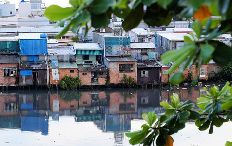 屋城市HOCHIMINHCityVietNANSNNOV2107年河滨居民在晚上雨后住一组临时房从金属板或红砖下降为临时住房靠近背景