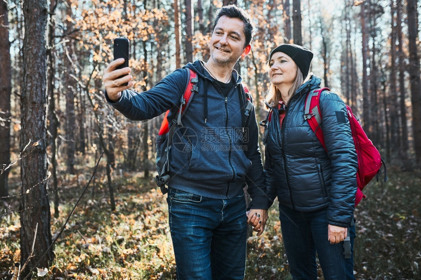 两人在度假旅行时拍自照片Hikers和背包在森林中行走的路上在阳光明媚的白天与自然相近的闲暇时间绿色娱乐荒野图片