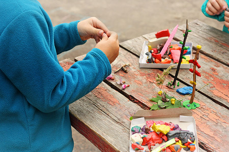 英雄小报素材身体桌子木头儿童玩户外游戏图像是儿童在红桃桌外面玩泥土的一部分儿童玩粘土和各种形状的天然素材以不同形状的粘土和各种天然素材背景