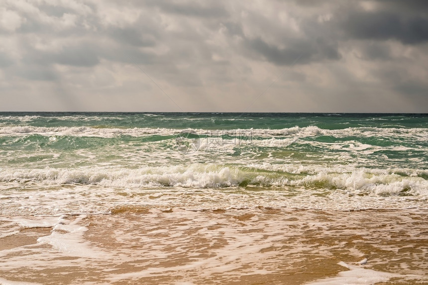 液体黑海岸沙滩上暴风雨清凉的明水温暖一天阳光照耀着空中的乌云全景平静图片