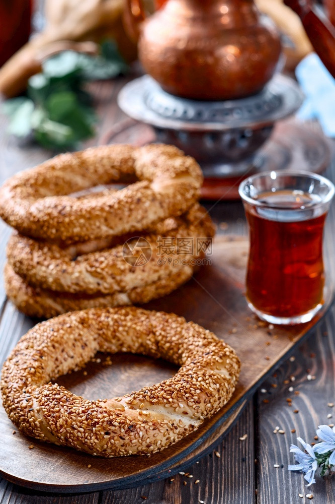 咖啡店模拟芝麻种子Gevrek或Kuluri传统白面包早餐用芝麻种子木制桌上有红茶的一杯阿马杜面条在土耳其吉夫雷克或库鲁里传统白图片