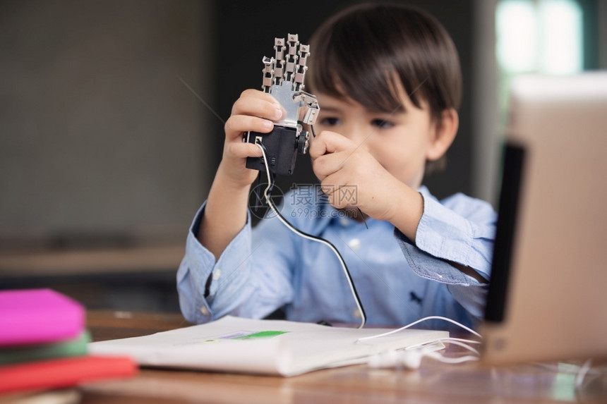 距离肢使用平板电脑做功课的自孤立儿童在被困19岁期间独自玩机器人臂的儿童家庭学校教育社会远程电子学习在线教育技术图片