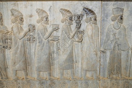 法尔斯一种伊朗希拉兹PersepolisFars省南部东楼梯阿帕达纳国王的Lydian大使馆佩戴者随身携带礼物浅浮雕旅游背景