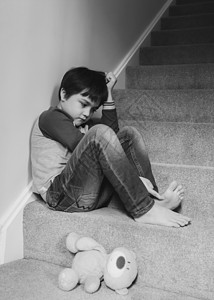 楼梯拐角情感悲伤的男孩子坐在楼梯的角落里精神健康心理痛情绪压抑的男孩子正坐在楼梯的拐角上校对PortnoyHigh地毯郁闷背景