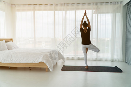 居家卧室做瑜伽的年轻女子图片