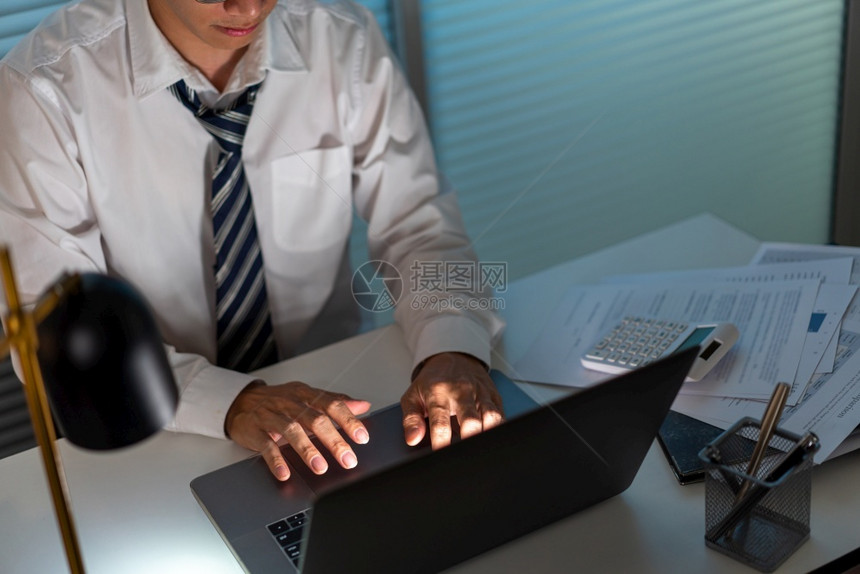担心超工作概念坐在办公桌旁的男子他工作重点是通过电脑笔记本进行工作沮丧图片
