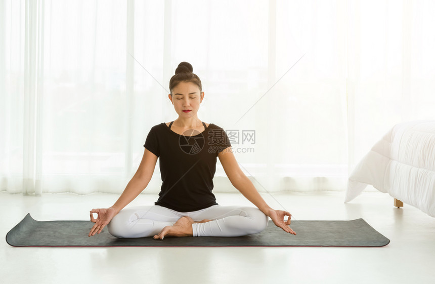 姿势会议中年妇女以轻松坐椅或苏哈萨纳做瑜伽在早上醒来后白卧室进行泥土默想和瑜伽运动放松和保健概念Sukhasana毯子图片