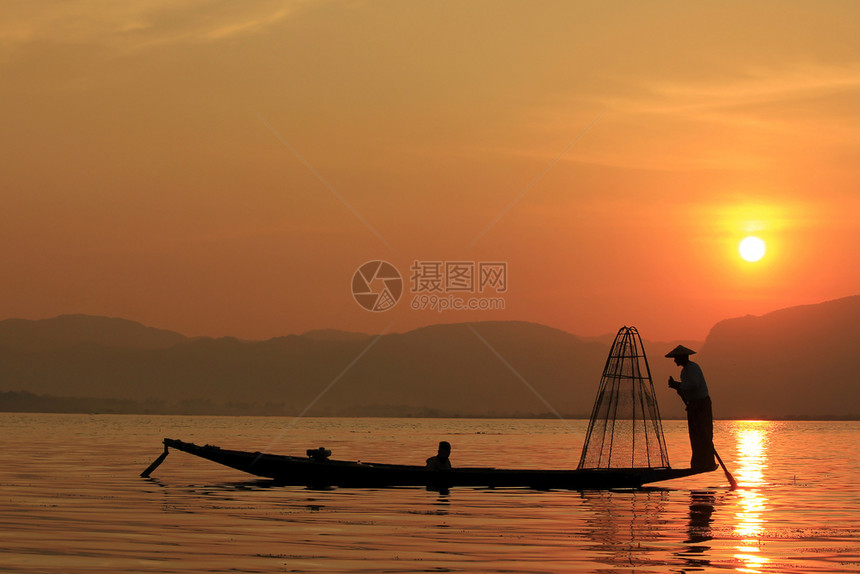 著名的太阳缅甸湖边一个渔民的轮廓图片