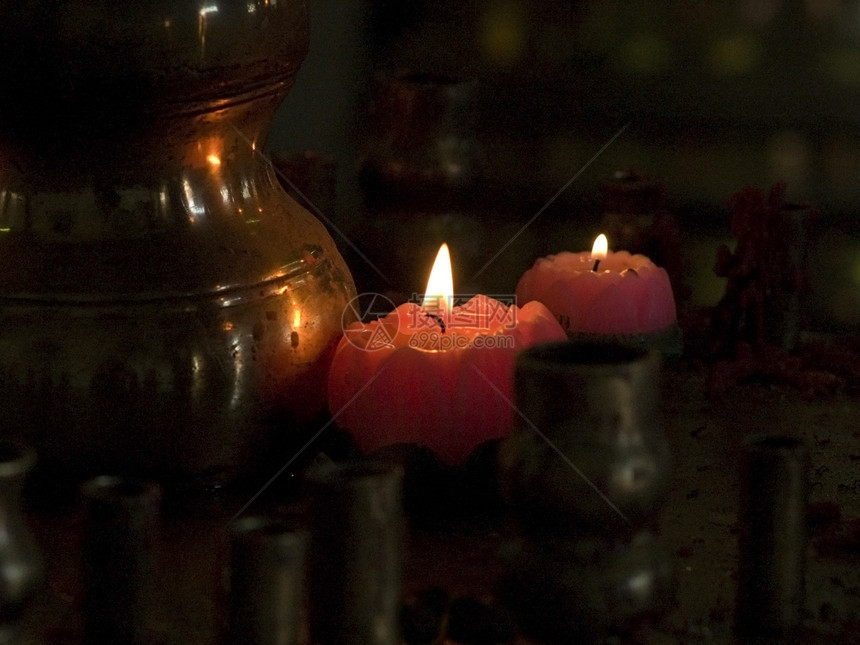 两个红蜡烛黄铜反射黑色红色火焰点燃情绪水壶图片
