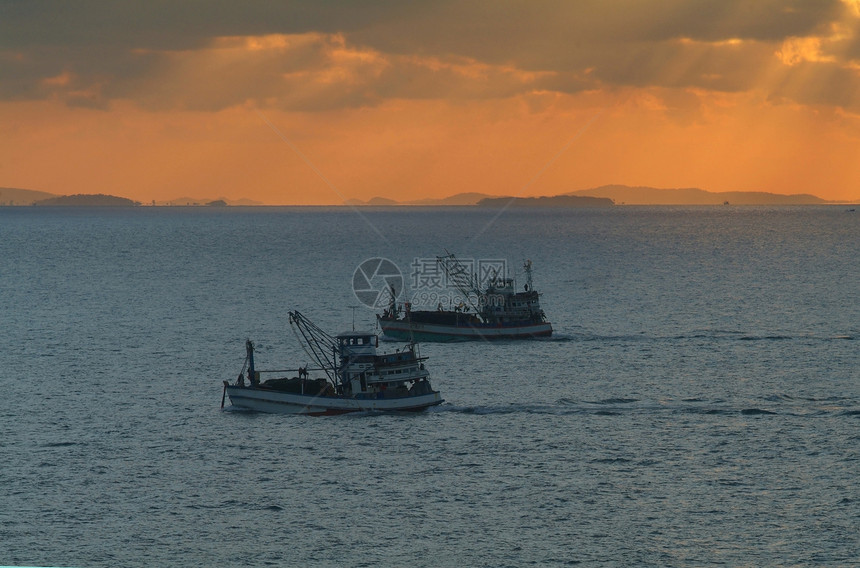 日出时渔船橙子太阳血管光束海洋海岸图片