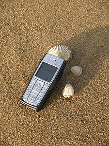 沙滩上的手机细胞贝壳闲暇海滩电话休息背景图片