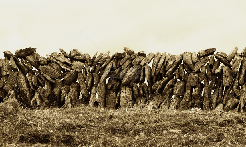 爱尔兰的石墙岩石棕褐色障碍农村文化苔藓路障场地天空农业图片